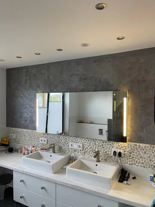 Badezimmer mit Waschtischwand in Spachteltechnik Betonoptik und Kieselmosaik