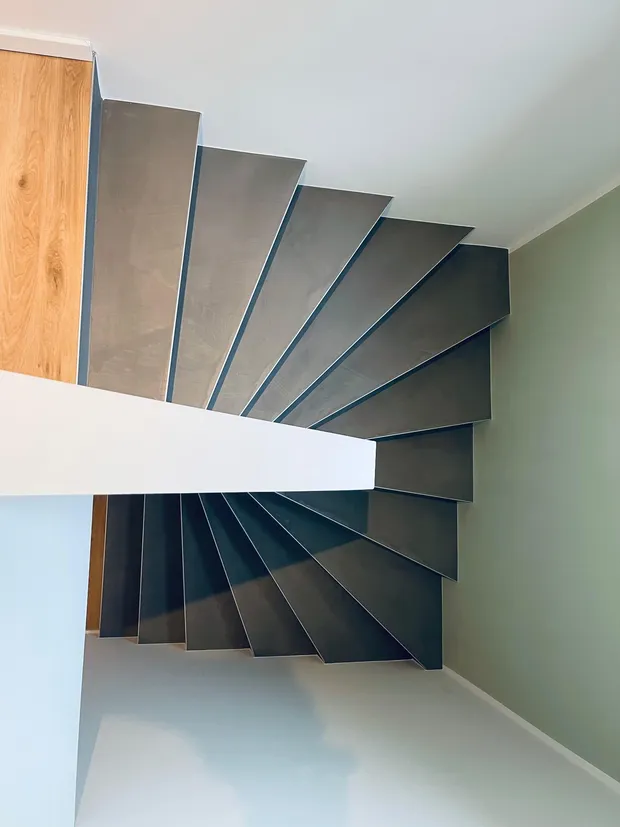 Treppenhaus mit salbeigrün gestrichener Wand und grau beschichteten Stufen, Malerarbeiten MB Petersen