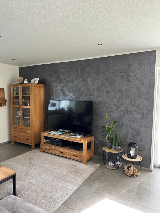 Wohnzimmer mit TV-Wand in Spachteltechnik Betonoptik Anthrazit, ausgeführt von MB Petersen Malerbetrieb bei Husum