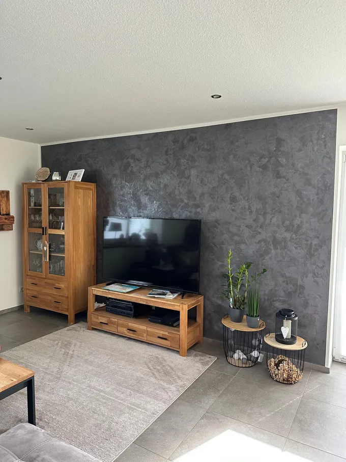 Wohnzimmer mit fugenloser TV-Wand in Spachteltechnik Betonoptik – Referenz von MB Petersen Malerbetrieb aus Ostenfeld bei Husum